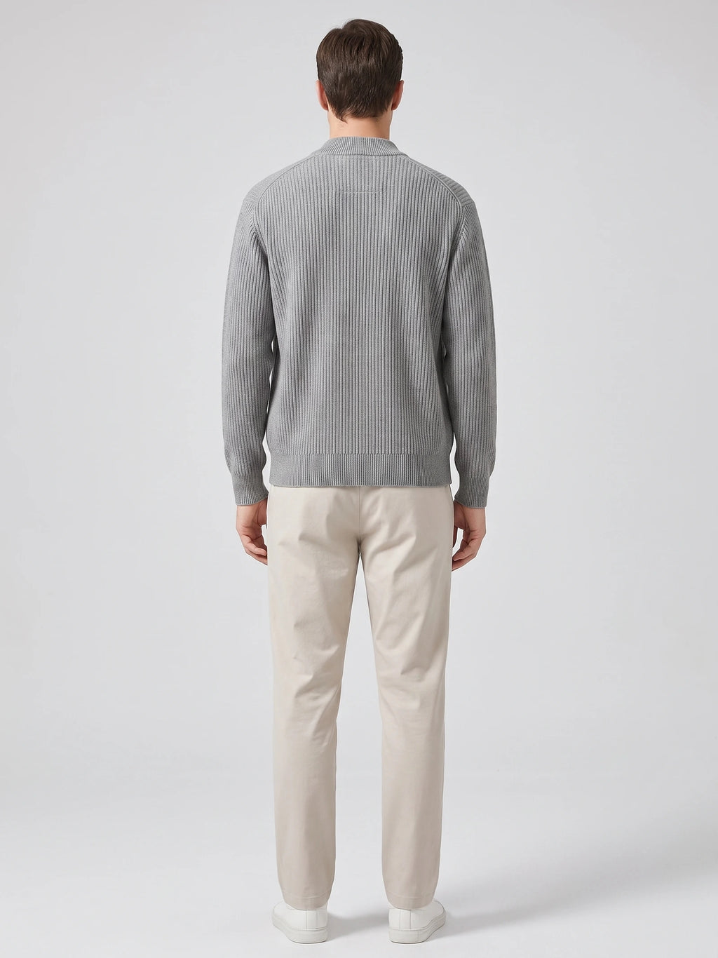Rear studio view of a model wearing a Gray zip up cardigan with ribbed knit texture, long sleeves, and a stand collar.