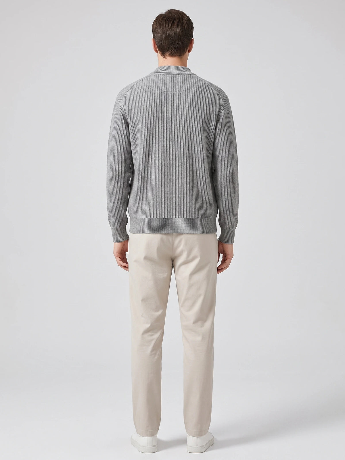 Rear studio view of a model wearing a Gray zip up cardigan with ribbed knit texture, long sleeves, and a stand collar.