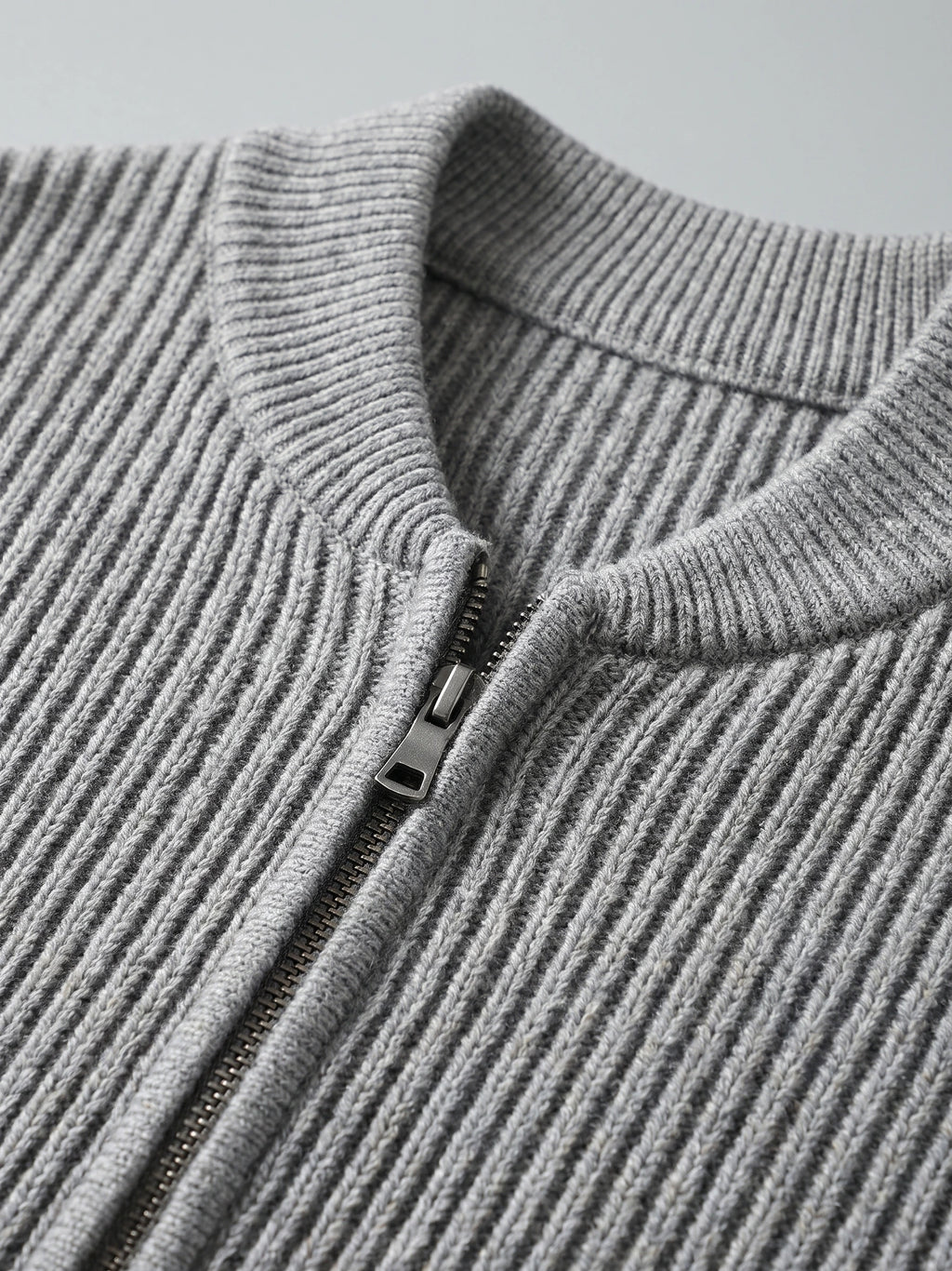 Close-up of the Gray men's zip up cardigan showing its ribbed knit stand collar and front zipper.