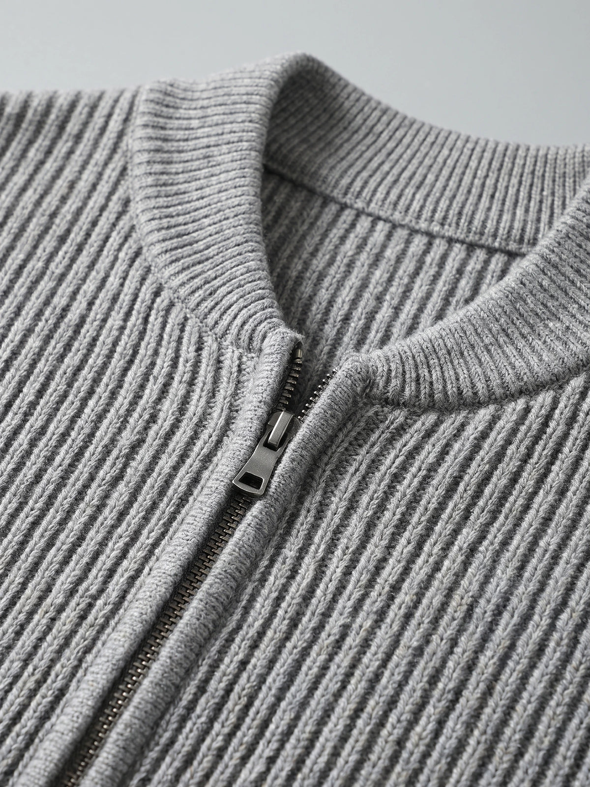 Close-up of the Gray men's zip up cardigan showing its ribbed knit stand collar and front zipper.