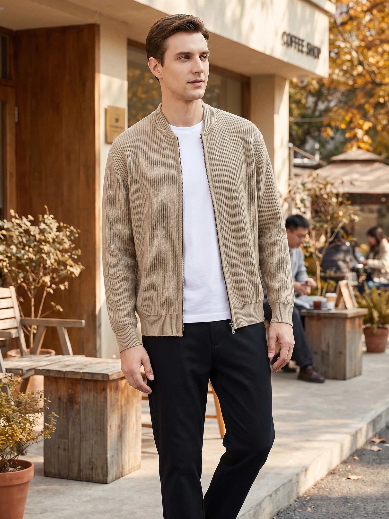 Model wearing a Khaki ribbed zip up cardigan with a stand collar while walking outside a café.