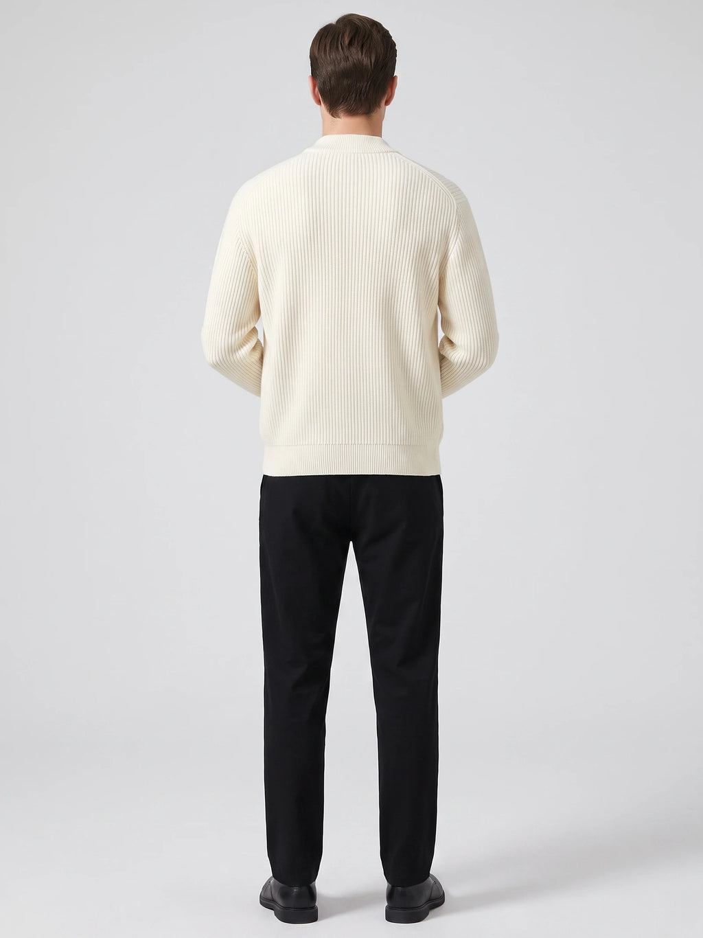 Rear studio view of a model wearing a White zip up cardigan with vertical ribbed knit texture and a stand collar.