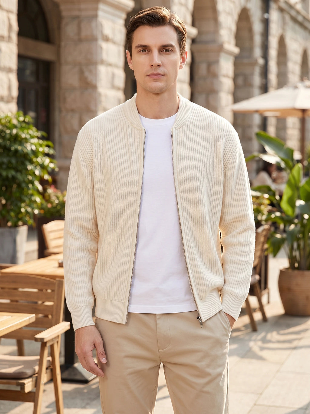 Man wearing a White ribbed zip up cardigan with a stand collar at an outdoor café.